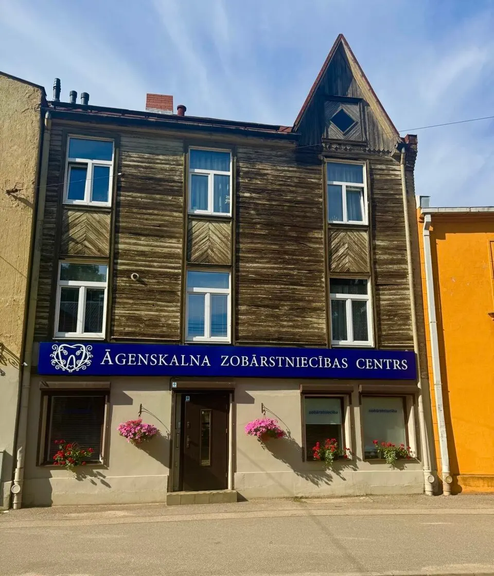 Klīnikas koka ēka Mazajā Nometņu ielā ar zilu izkārtni